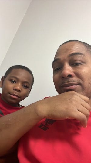 Noah Cage, left, sits with his dad, Sheldon Cage. Sheldon now lives in a development for veterans created by Detroit Rescue Mission Ministries in Highland Park where Noah can visit him.