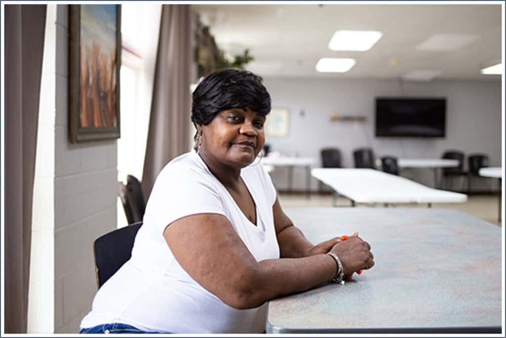 African American woman, Angela, sitting at a table